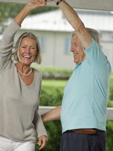 Ein fröhliches, älters Paar tanzt beschwingt.