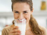 Eine Frau mit Nahrungsmittelunverträglichkeit trinkt Milch