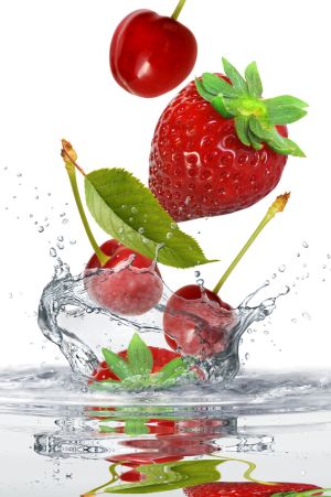 Rote Früchte fallen ins Wasser
