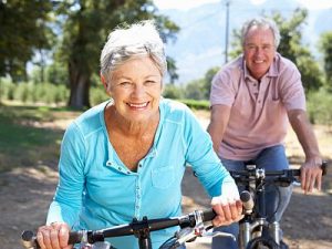 Ein fittes und aktives Seniorenpaar ist auf Mountain-Bikes unterwegs.