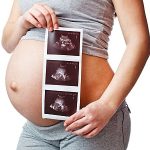 Schwangere Frau mit Ultraschallbild.