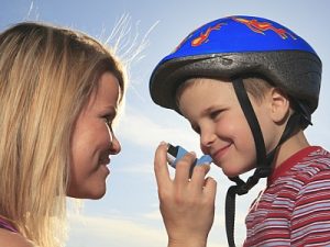 Eine Frau hilft einem Kind mit dem Asthmaspray.