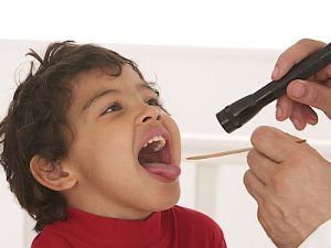 Kind mit Halsschmerzen wird vom Kinderarzt untersucht.