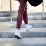 Frau mit Turnschuhen und roter Hose steigt Treppen