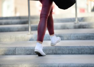 Frau mit Turnschuhen und roter Hose steigt Treppen