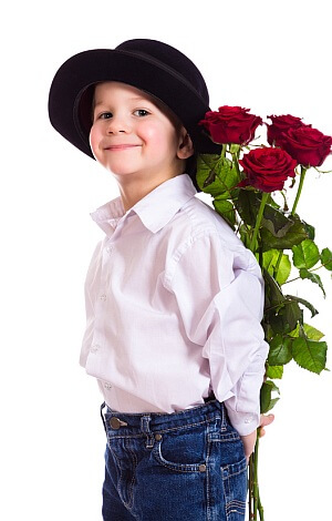Kleiner Junge mit Hut und roten Rosen.