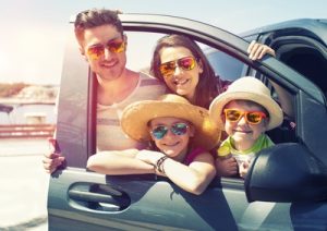 Familie im Auto mit Sonnenbrillen.
