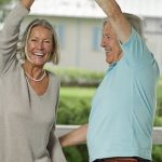 Ein fröhliches, älters Paar tanzt beschwingt.