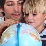 Vater und Sohn betrachten einen Globus